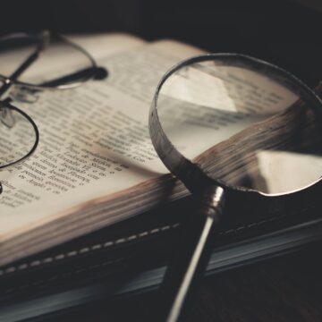 magnifying glass and glasses over bible